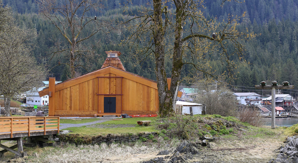  The Shakes Tribal House on Shakes Island in Wrangell, Alaska. The Three Frogs totem is to the right and there are three bald eagles in the cottonwood trees. The immature bald eagle is all brown so it is difficult to see.  