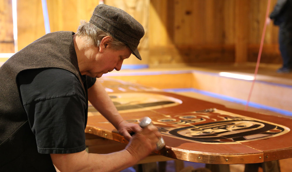 Master Carver Steve Brown forms copper to the screen for the Shakes Tribal House.