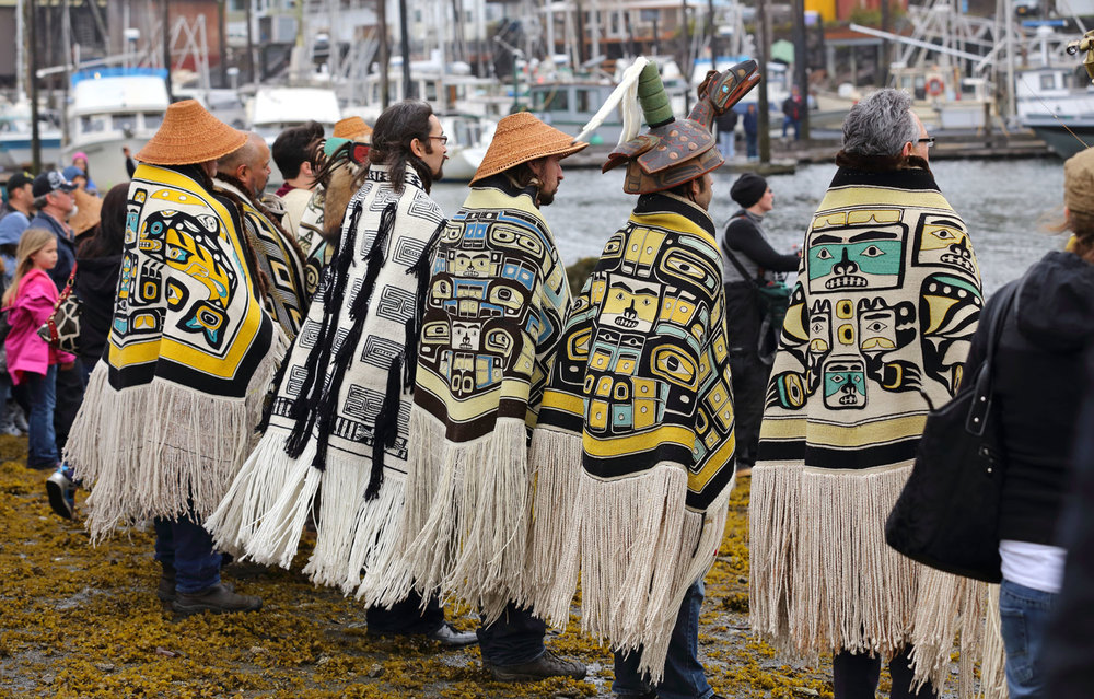 Alaska Native Elders and clan leaders wearing Chilkat and ravenstail blankets.