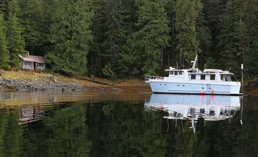 The boat moored to the pilings at the cabin. 