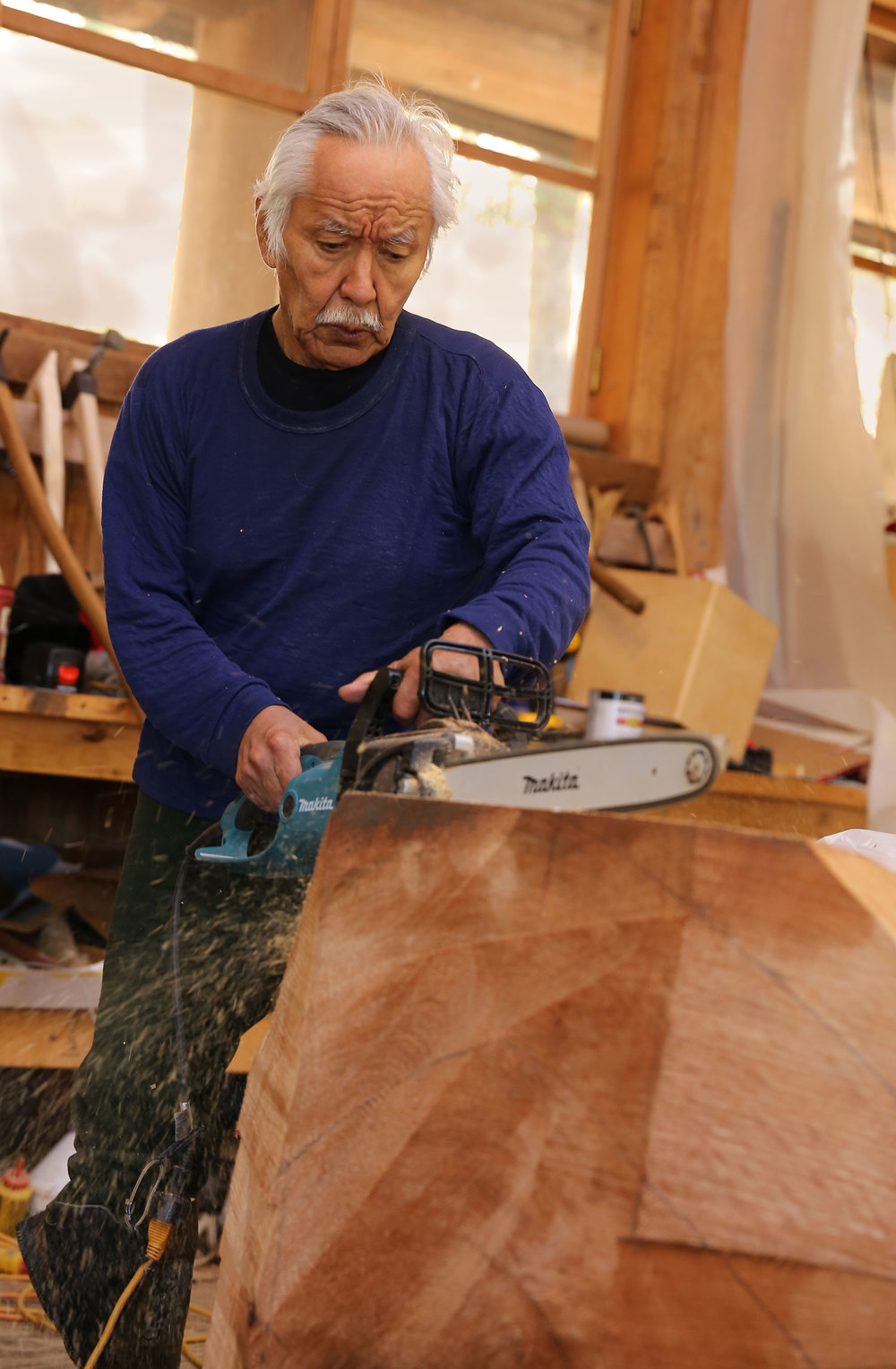 Nathan Jackson makes some initial cuts in a cedar log.