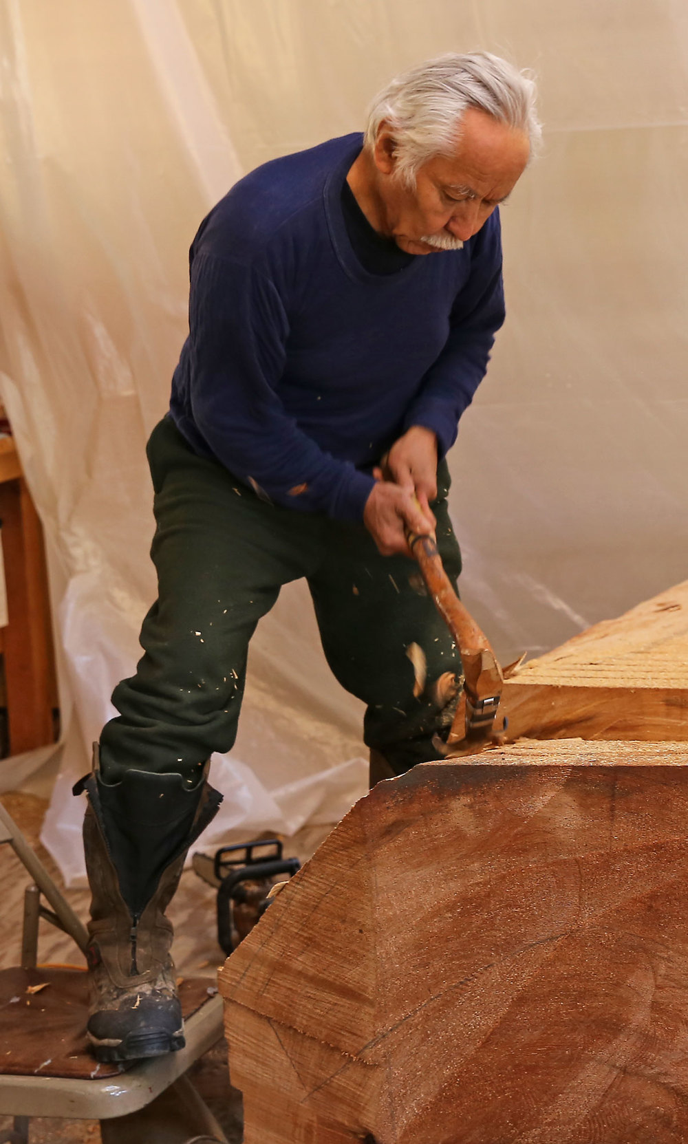 Chips fly as Nathan removes material with the adze.