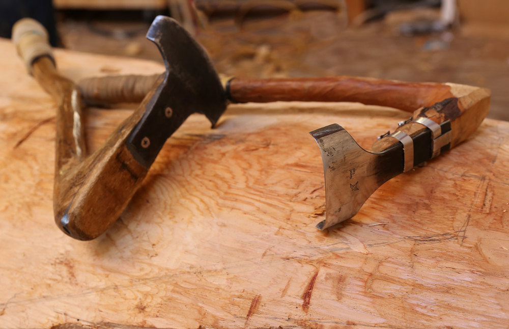 The adze head is attached to a handle made from a natural bend in an alder.