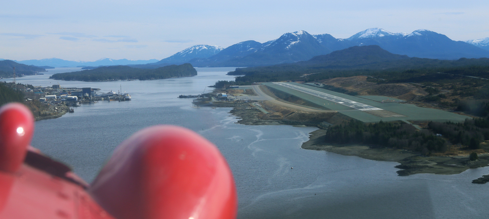 Flying over Tongass Narrows with Ketchikan International Airport on Gravina Island to the right and Ketchikan on Revillagigedo Island to the left. In the middle there are a few residents on Pennock Island.
