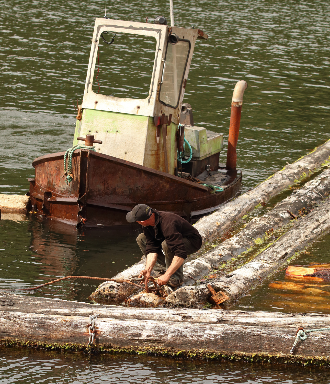 Boom man watching boat while handling shackle Prince of Wales Island Southeast Alaska