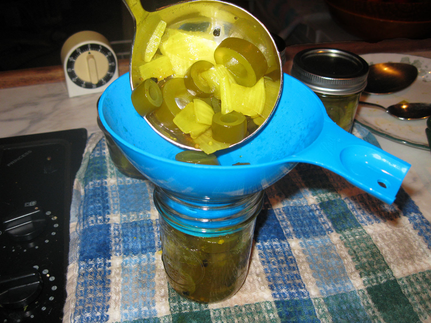 Ladling kelp pickles into the jar. 