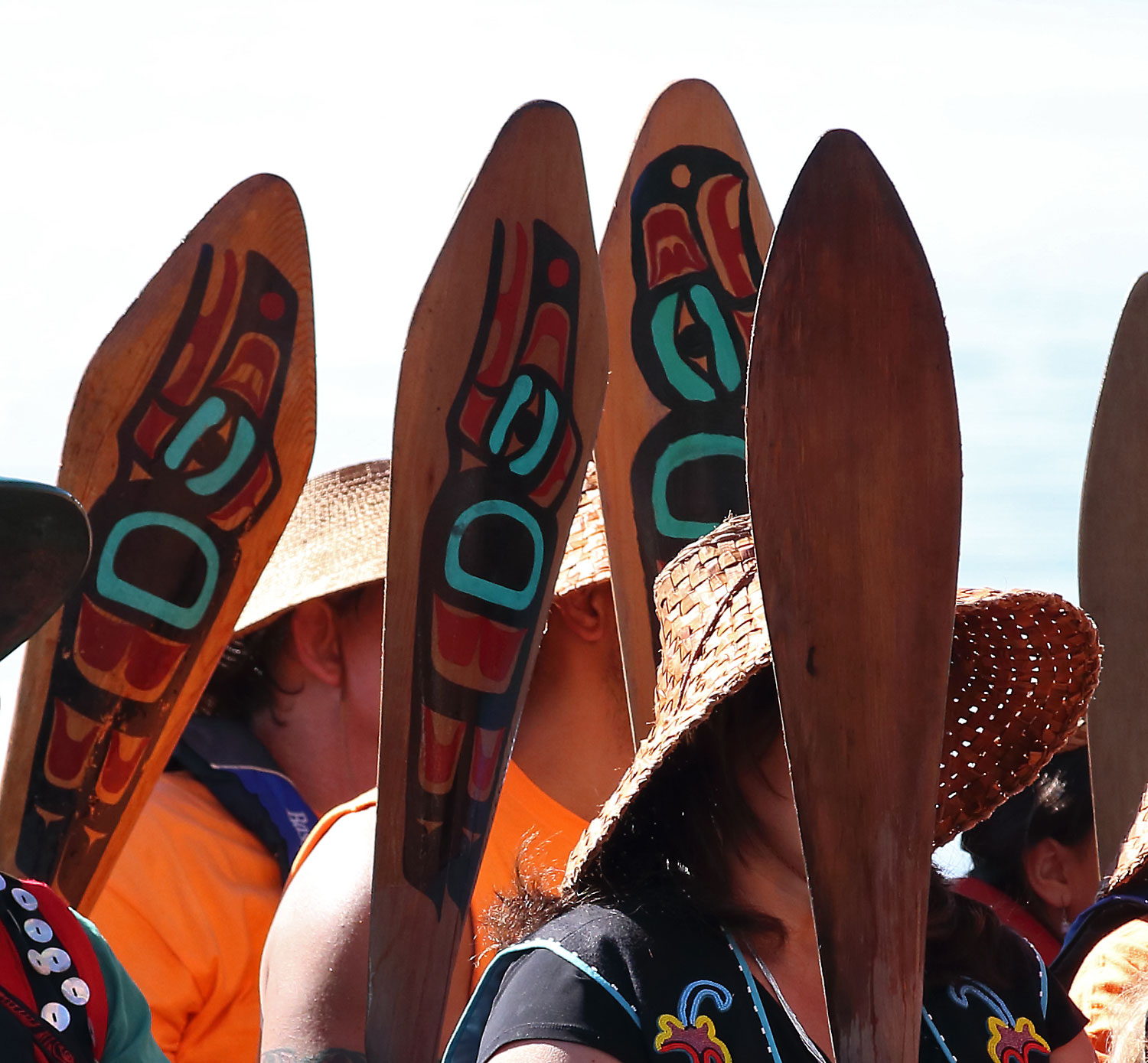 Paddles raised, the Haida people wait to go ashore.