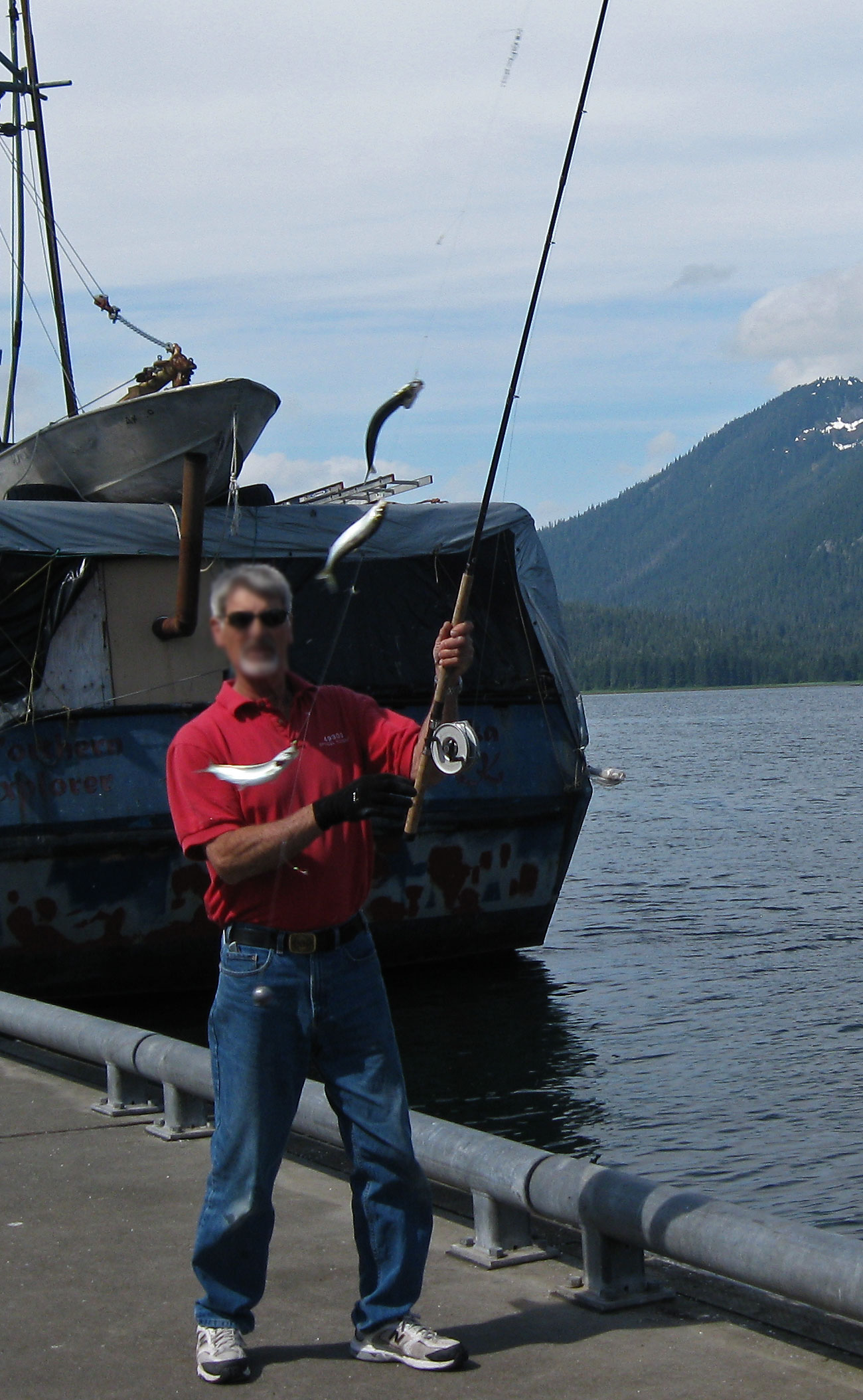 A retiree catching three herring at once on a herring jig during his visit to Petersburg.