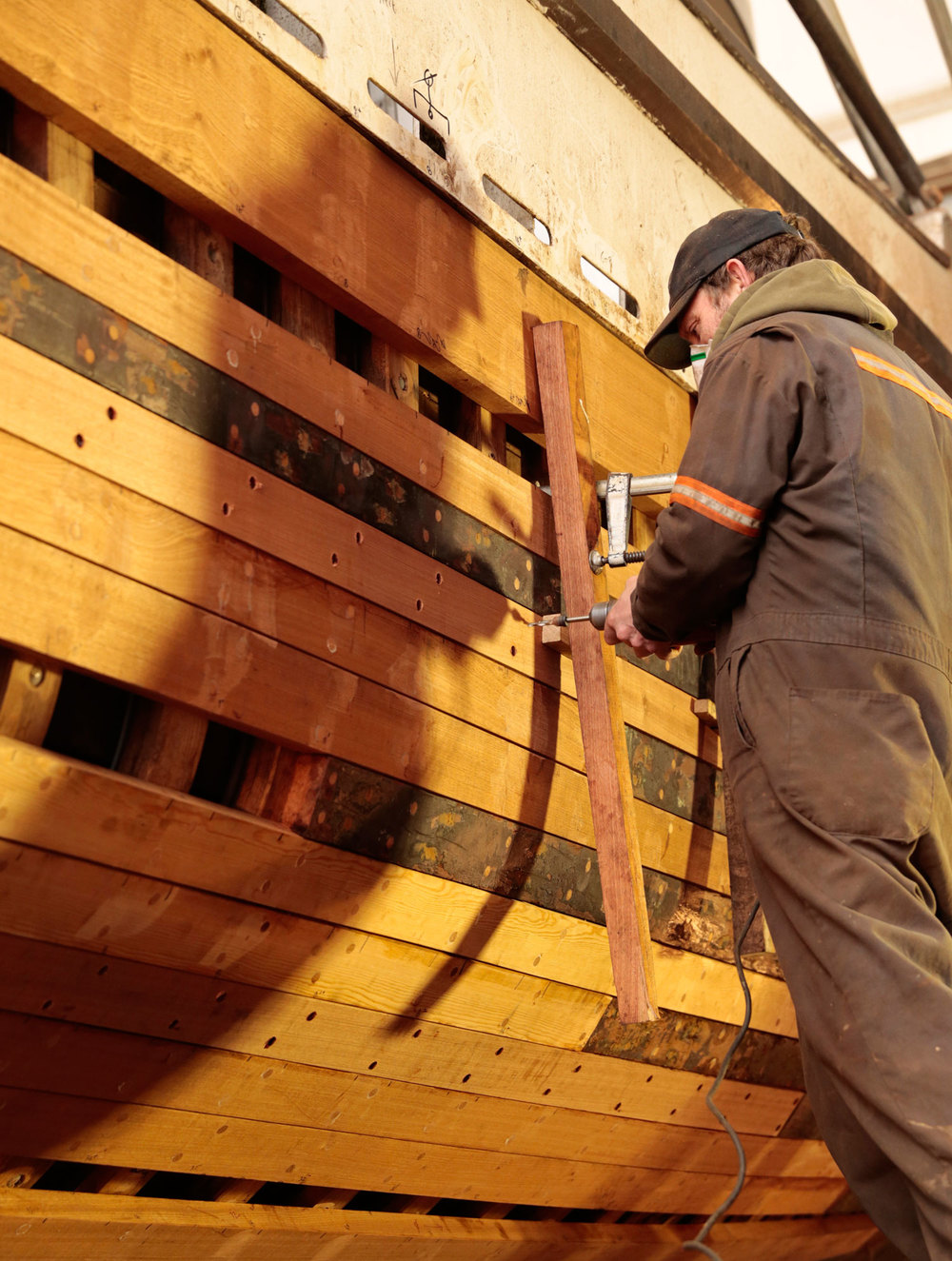 Mike File of Petersburg fastens a new plank to F/V Siren's hull.