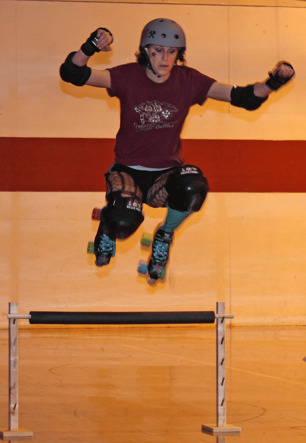 Kooks Deluxe of the Garnet Grit Betties Roller Derby Team practicing a jump.
