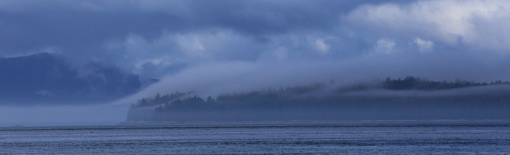 A marine layer slipping up over an island.