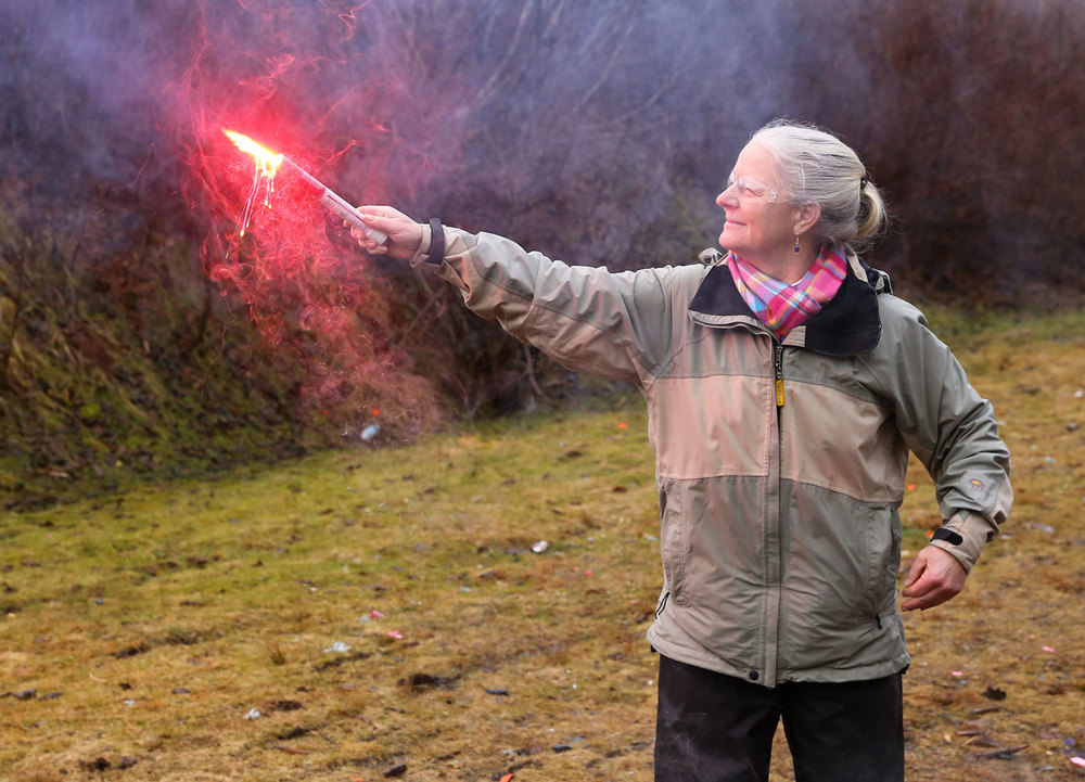 Get a good grip on the bottom of the flare and hold it out over the side of the boat. Stand where you can grasp the boat with your other hand.  See the molten plastic dripping from the flare?